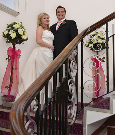 Bride and groom photographed on the grand staircase at the John Godber Centre